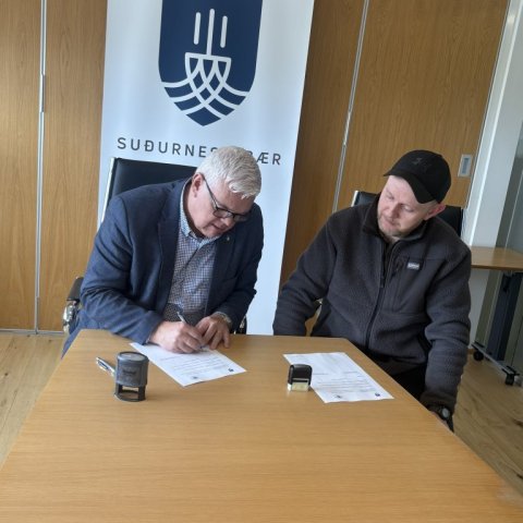 Magnús Stefánsson bæjarstjóri og Eiður Gils Brynjarsson formaður Hestamannafélagsins Mána undirrita samkomulag.